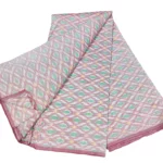 cotton silk fabric with a traditional ikat pattern featuring multicolored diamond motifs arranged in a symmetrical design."