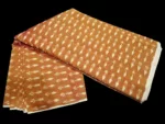 Tie and dye cotton fabric with intricate ikat patterns on a loom