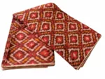 Handwoven Pochampally ikat fabric with red, mustard, and white diamond pattern, traditional geometric design on cotton or cotton-silk textile.